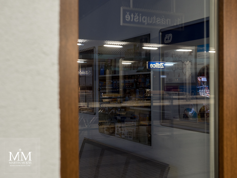 View into a railway station waiting room through a glass, glare and reflections. Photograph created with the Olympus M. Zuiko digital ED 25 mm 1:1.2 Pro.