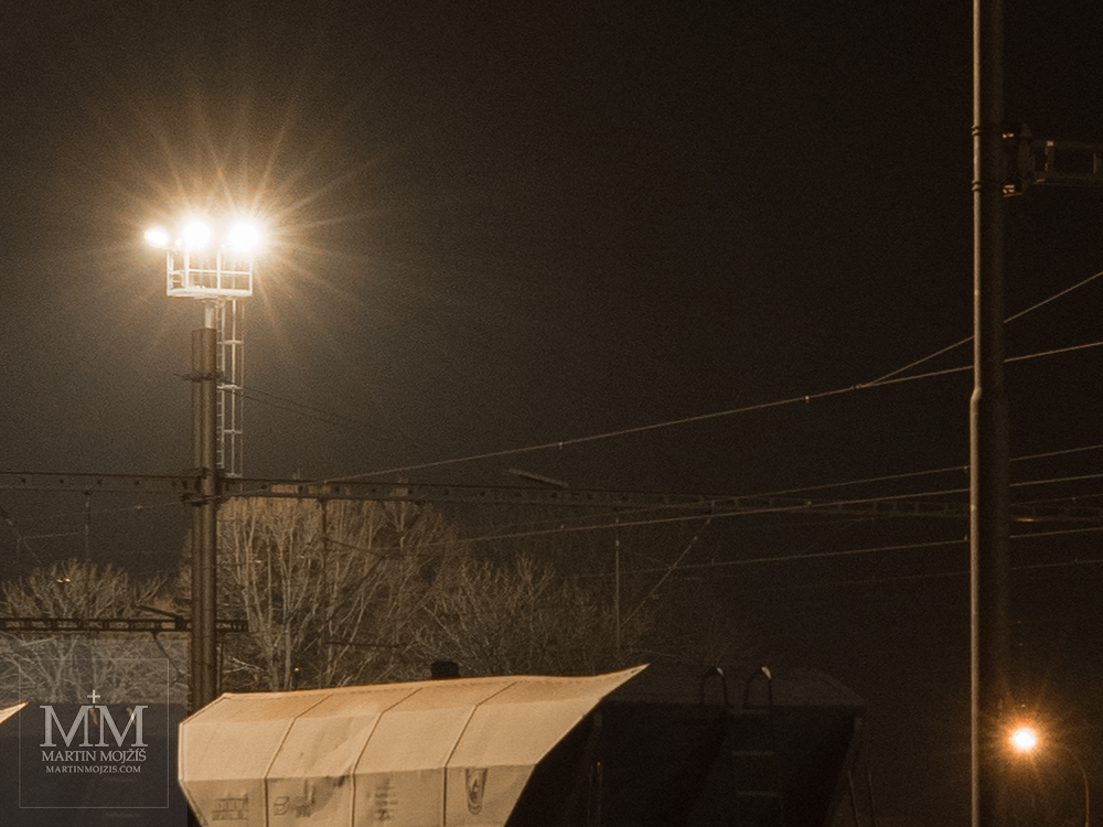 Spotlights illuminate a night railway station. Photograph created with the Olympus M. Zuiko digital ED 25 mm 1:1.2 Pro.