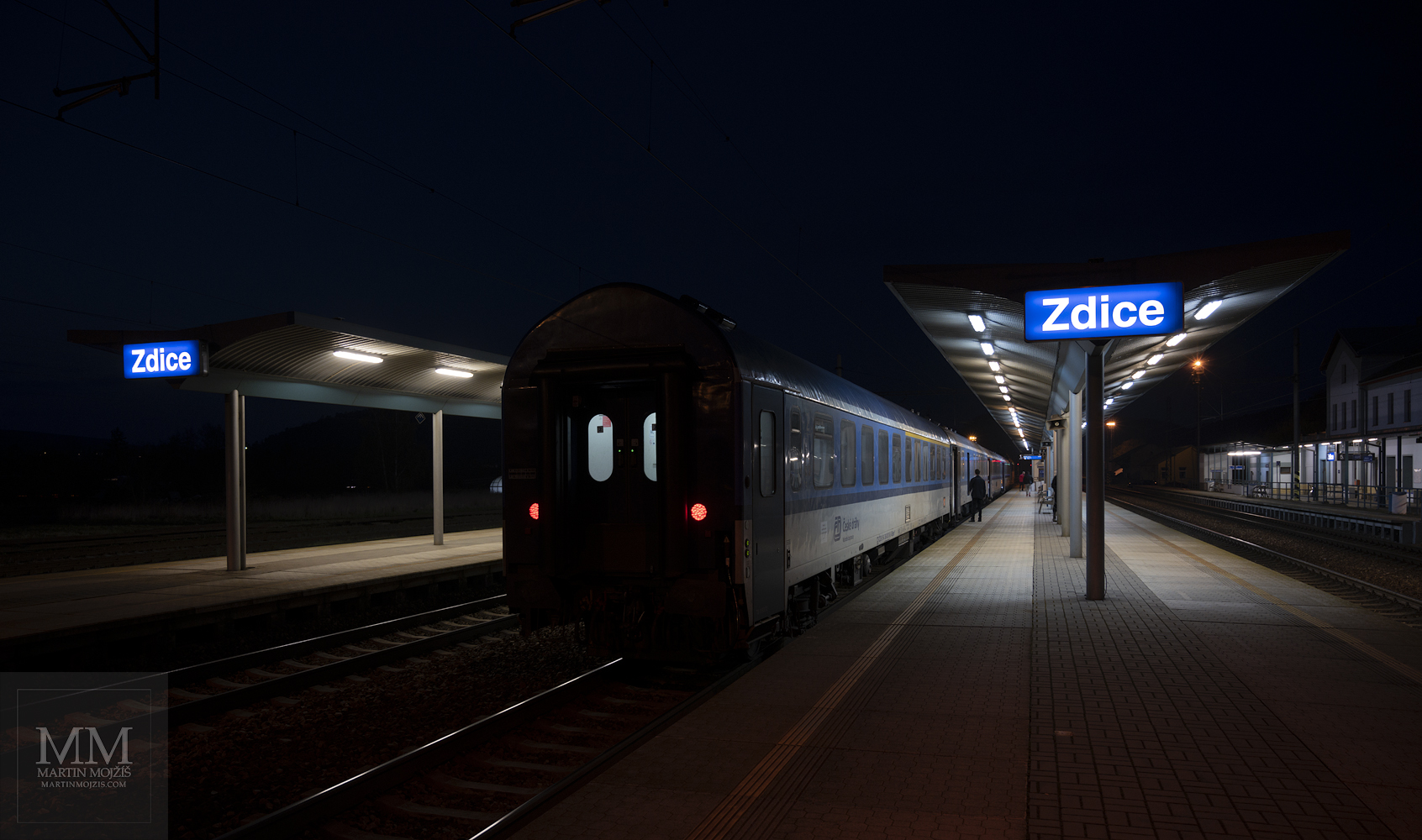 Passenger train on a railway station at night.