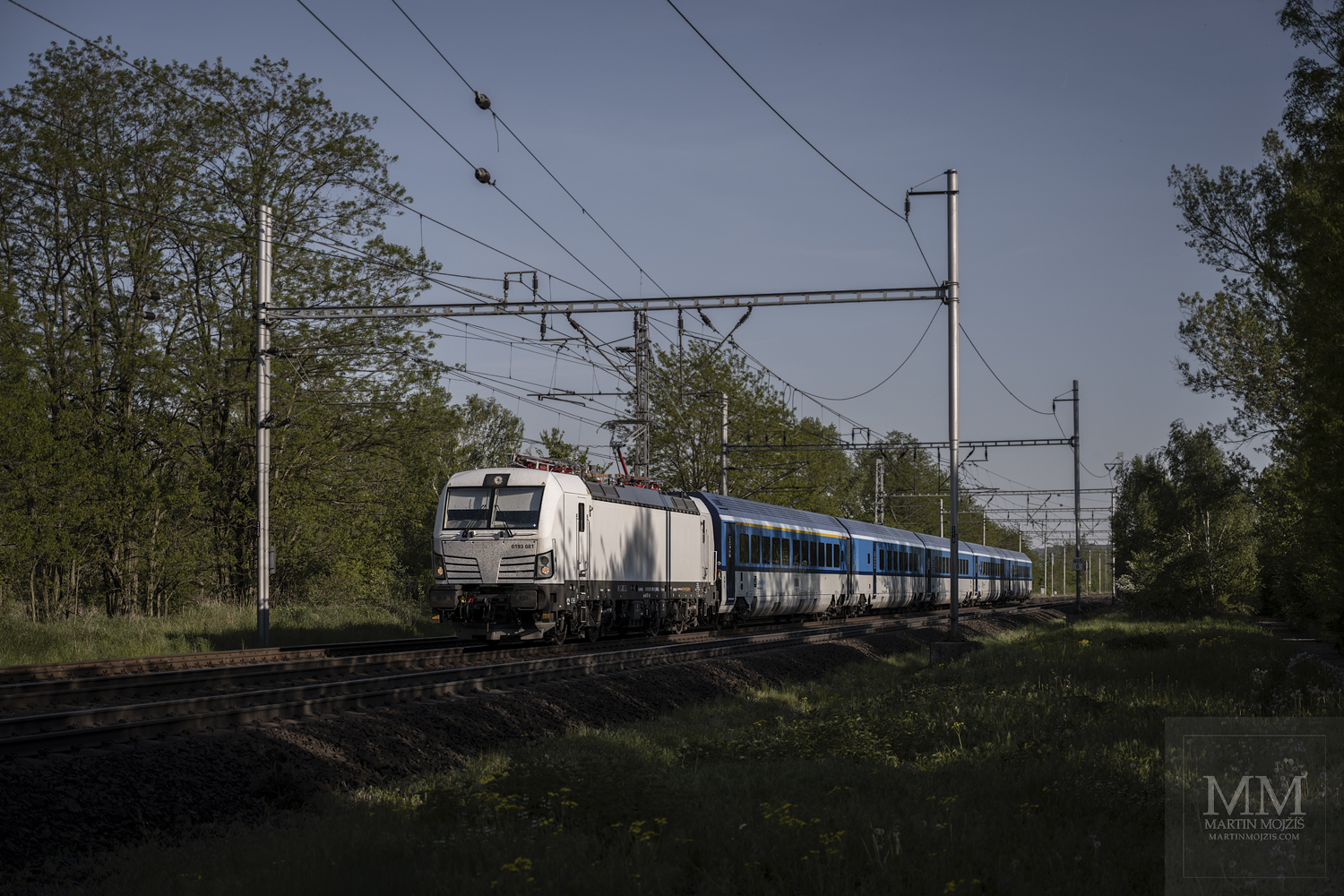 White locomotive Siemens Vectron 6193 681 in head of a passenger train in the direction Usti nad Labem.