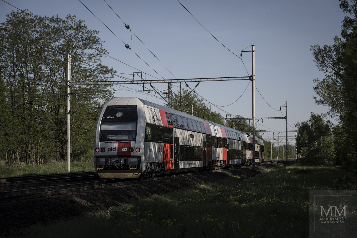 Passenger train 971 060-9 in the new colors of PID going in the direction Kralupy nad Vltavou.