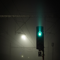 Noc, železniční světelné návěstidlo signalizuje Volno.
