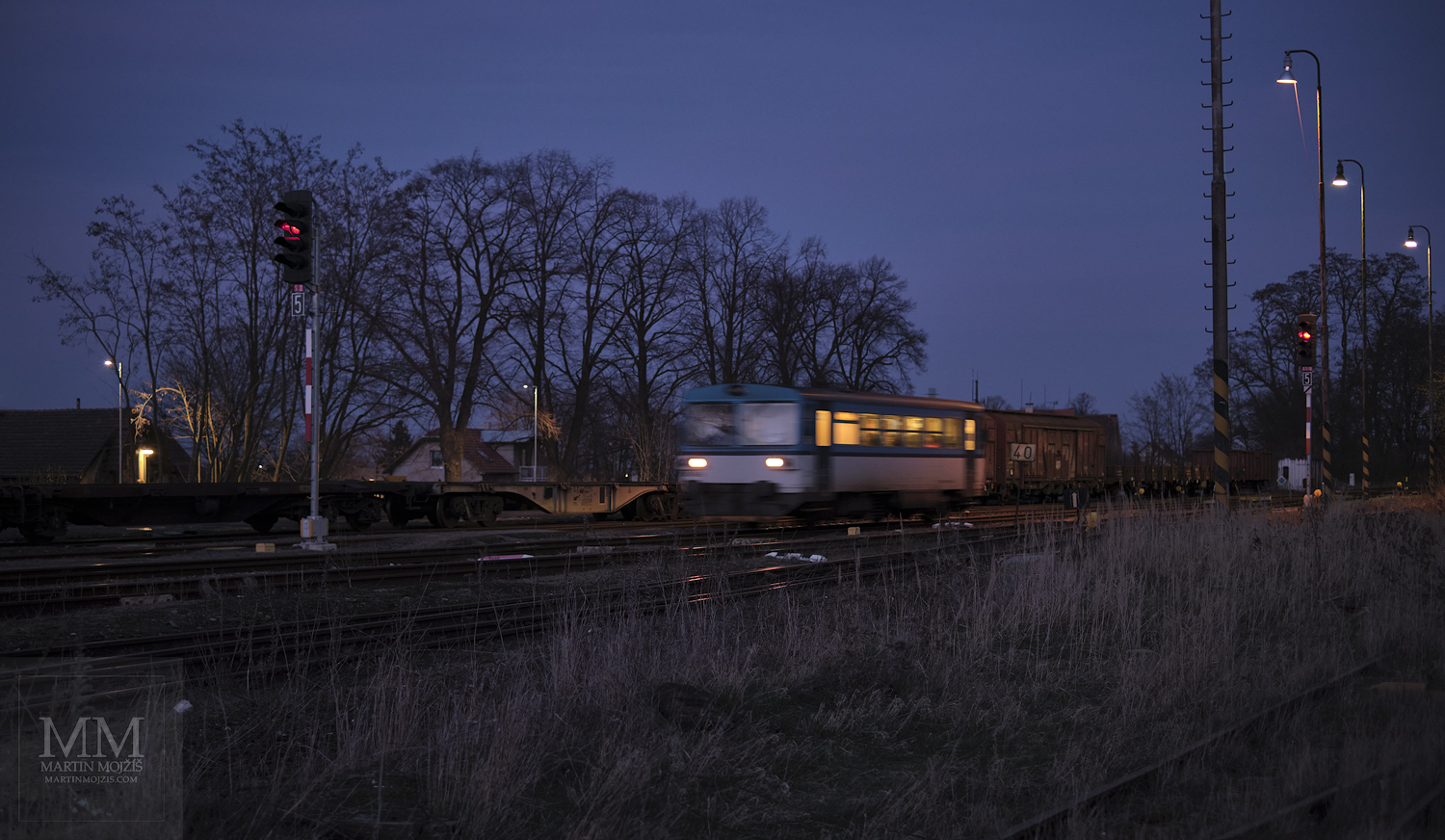 Velkoformátová umělecká fotografie motorového vlaku přijíždějícího na nádraží za soumraku. Martin Mojžíš.