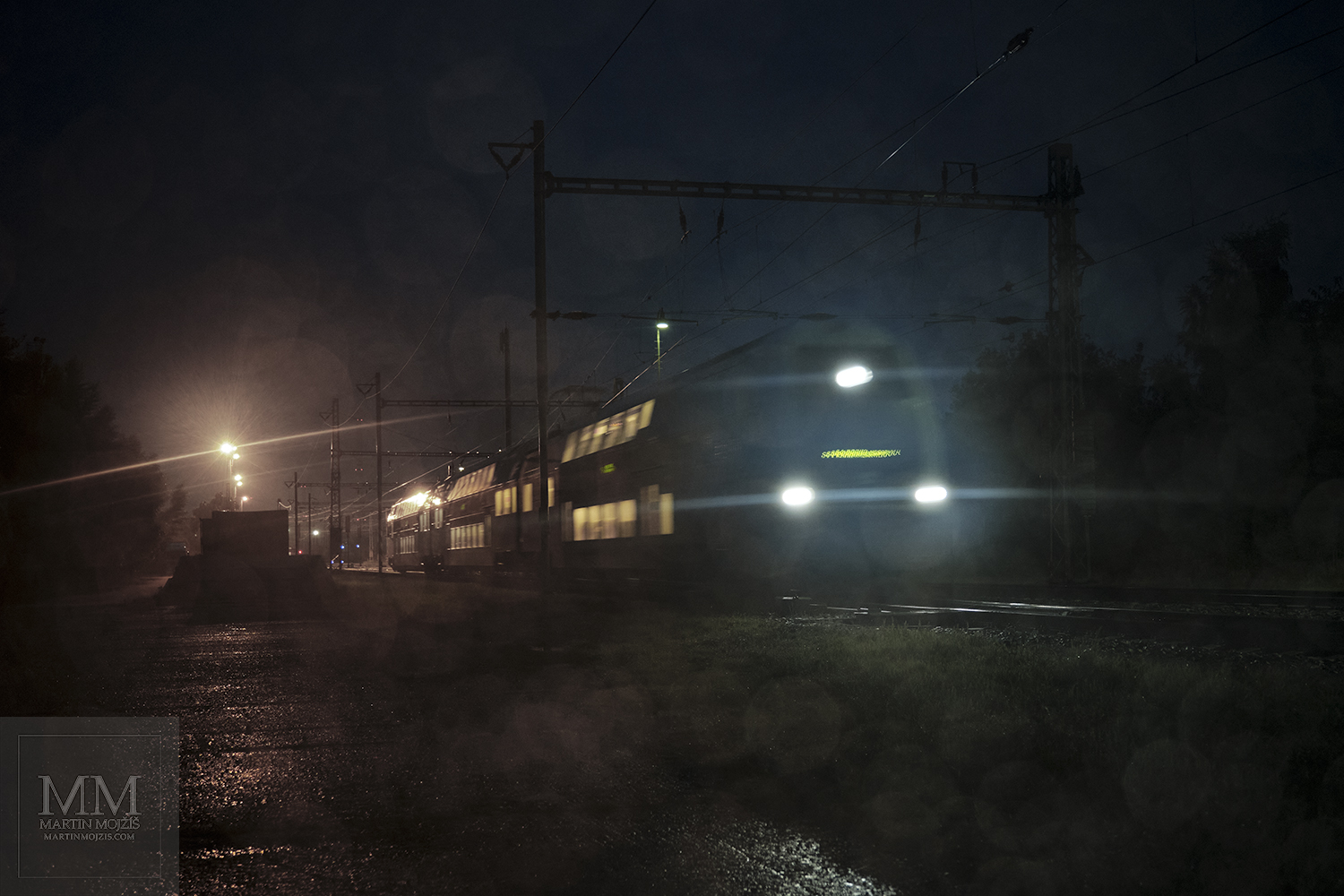 Vlak jedoucí deštivým ránem před svítáním. Umělecká fotografie s názvem RÁNO V TICHU DEŠTĚ. Fotograf Martin Mojžíš.