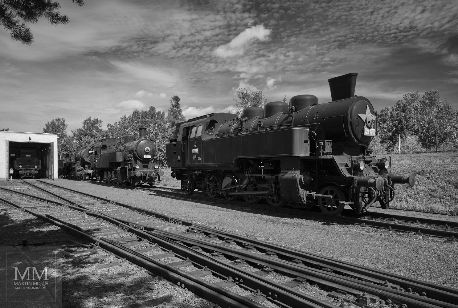 Parní lokomotivy na kolejích v letním odpoledni. Umělecká černobílá fotografie s názvem KLID LETNÍHO ODPOLEDNE I. Fotograf Martin Mojžíš.