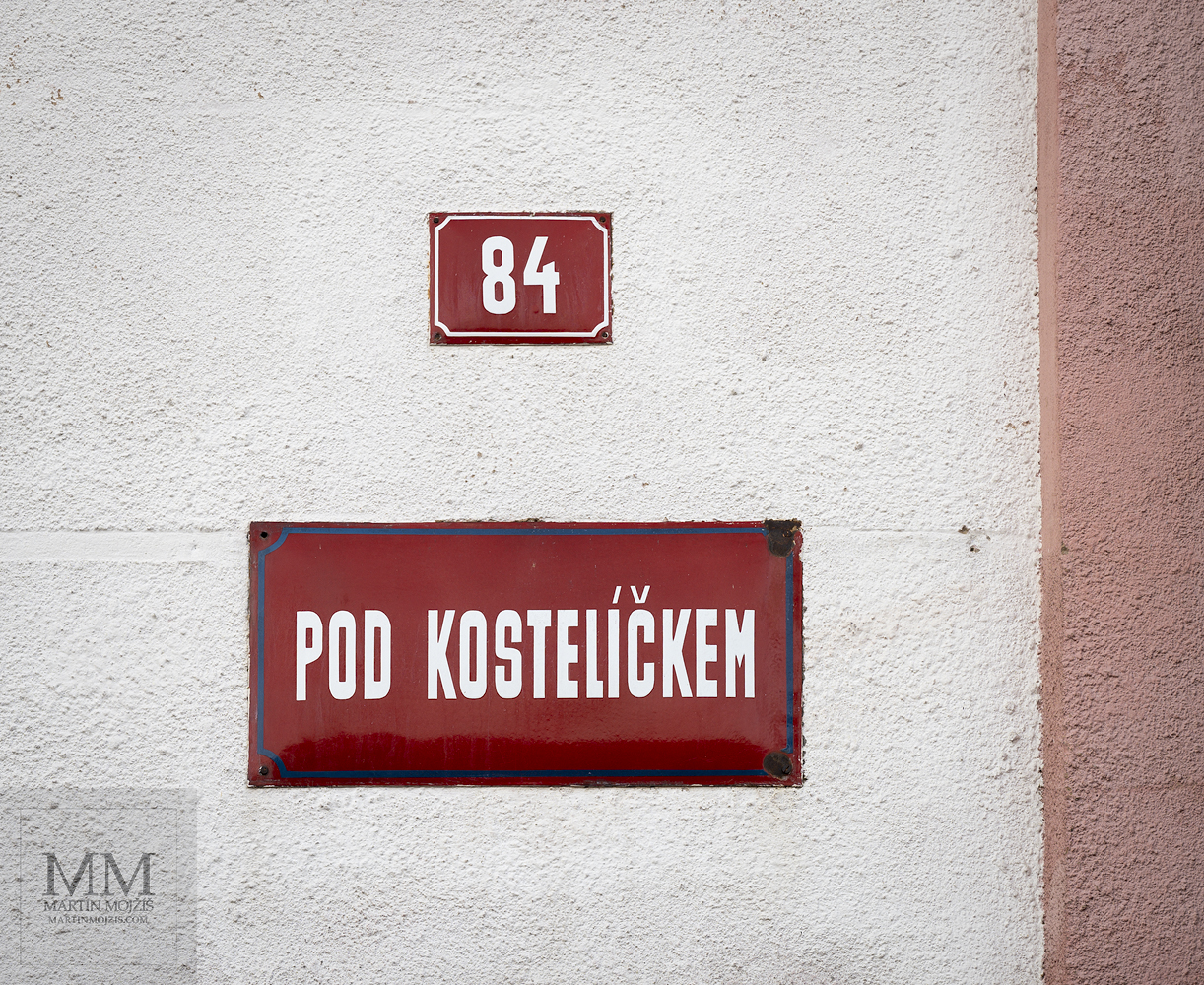 Table with a name of a street and a house number on a wall. Fine art photograph BELOW A TINY CHURCH II, photographed by Martin Mojzis.
