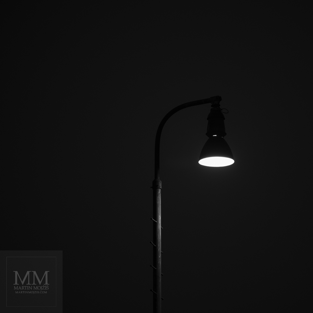 A shining railway lamp. Fine art black and white photograph LIGHT IN THE NIGHT SILENCE, photographed by Martin Mojzis.
