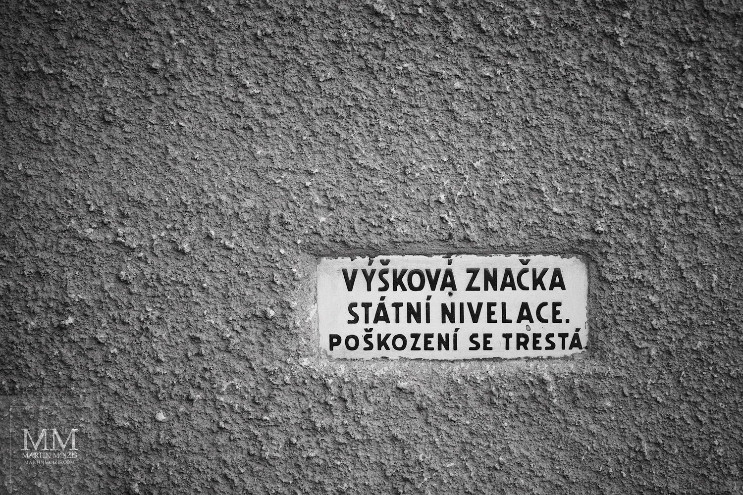 Tabulka Výšková značka státní nivelace. Umělecká černobílá fotografie s názvem VÝŠKOVÁ ZNAČKA. Fotograf Martin Mojžíš.