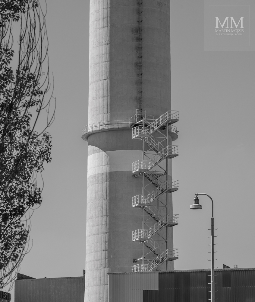 Schodiště u vysokého komínu elektrárny Prunéřov I, nyní již neexistující. Umělecká černobílá fotografie s názvem SCHODY MINULOSTI II. Fotograf Martin Mojžíš.
