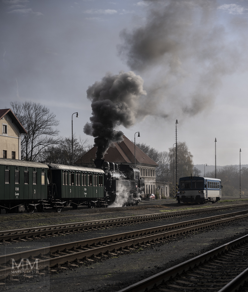 Parní lokomotiva a motoráček na nádraží. Umělecká fotografie s názvem V POLOVINĚ PODZIMU. Fotograf Martin Mojžíš.