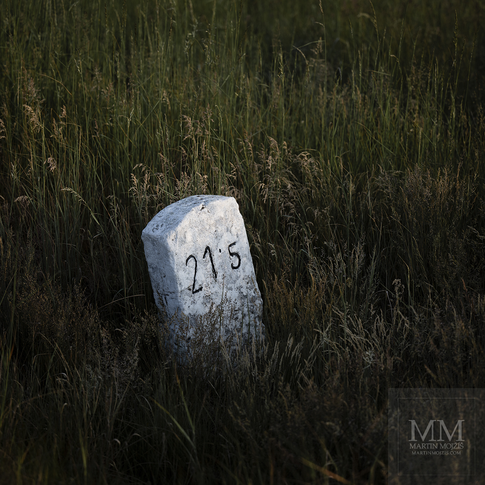 Railway hectometer stone in tall grass. Fine art large format photograph NOT FAR FROM THE TWENTY FIRST KILOMETER I, photographed by Martin Mojzis.