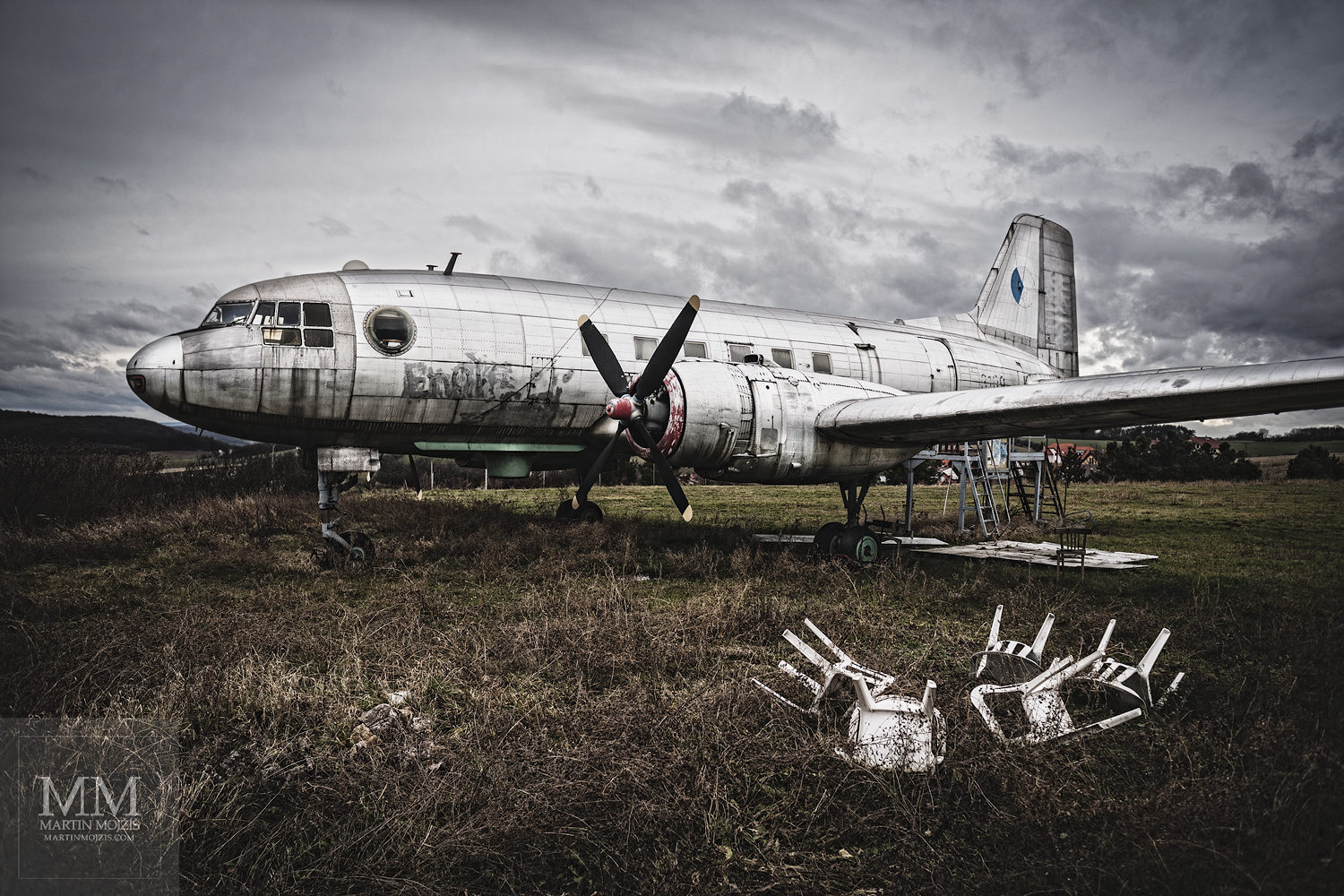 Airliner on a meadow. Photograph with title MEADOW WITH WHITE CHAIRS.
