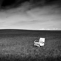 Black and white photograph of an abandoned armchair in the middle of a field. Introductory photograph of large format fine art photographs gallery Welcome to my House of photographer Martin Mojzis.