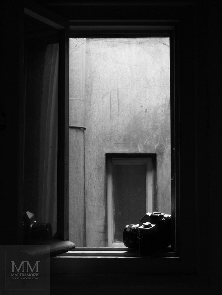Photographic camera lying on the window frame. Photograph with the title MASTER.