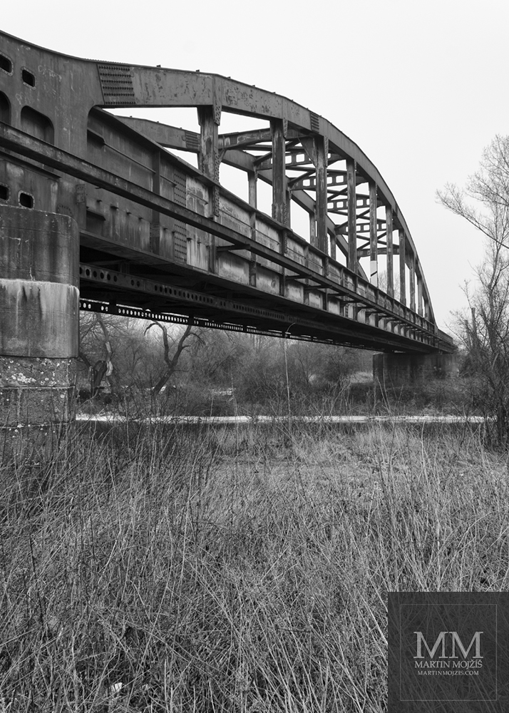 Black and white Fine Art photograph of a steel railway bridge with title ABOVE RIVER. Photographer Martin Mojzis.