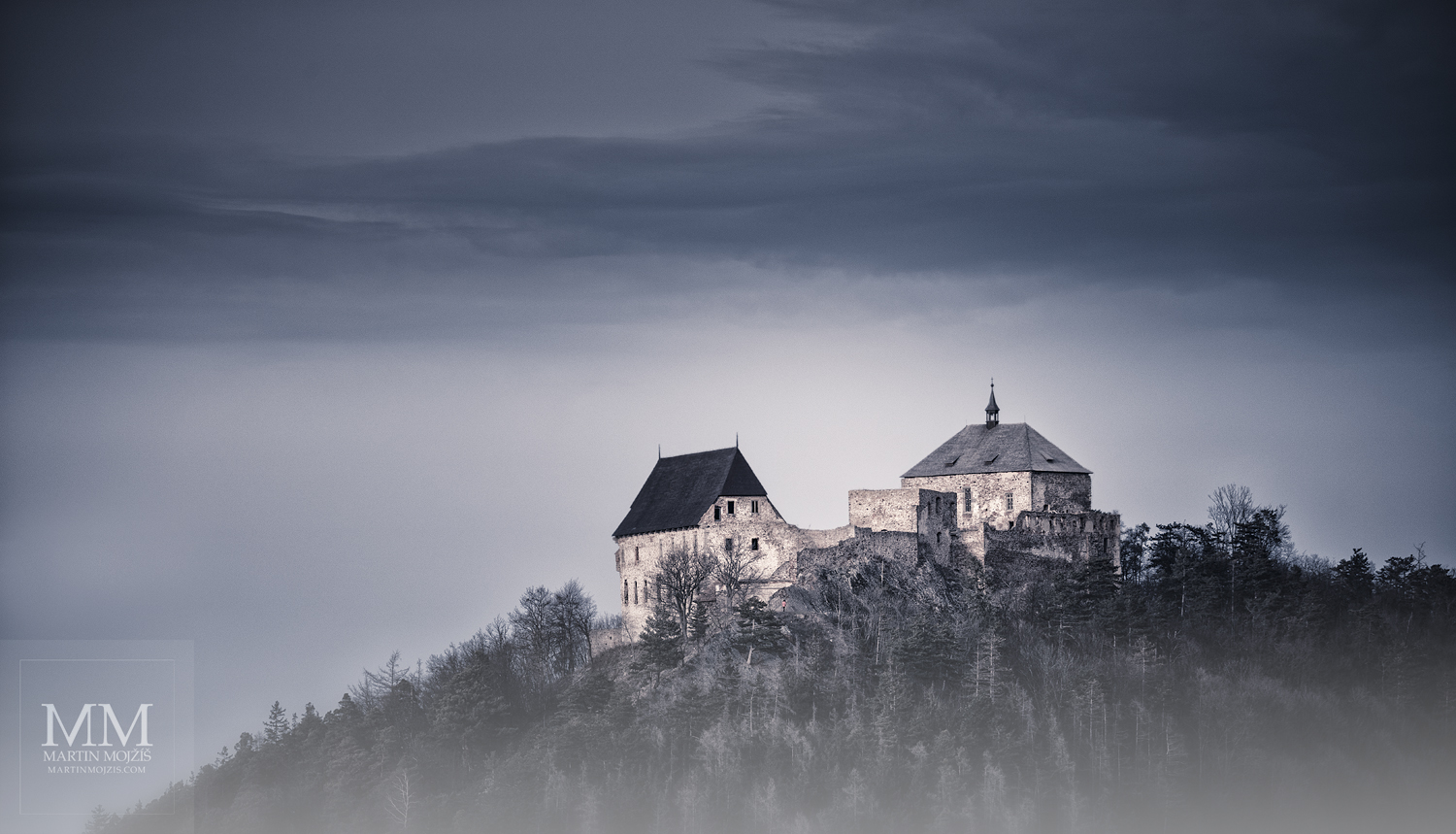 Velkoformátová umělecká fotografie hradu na vrcholu hory.