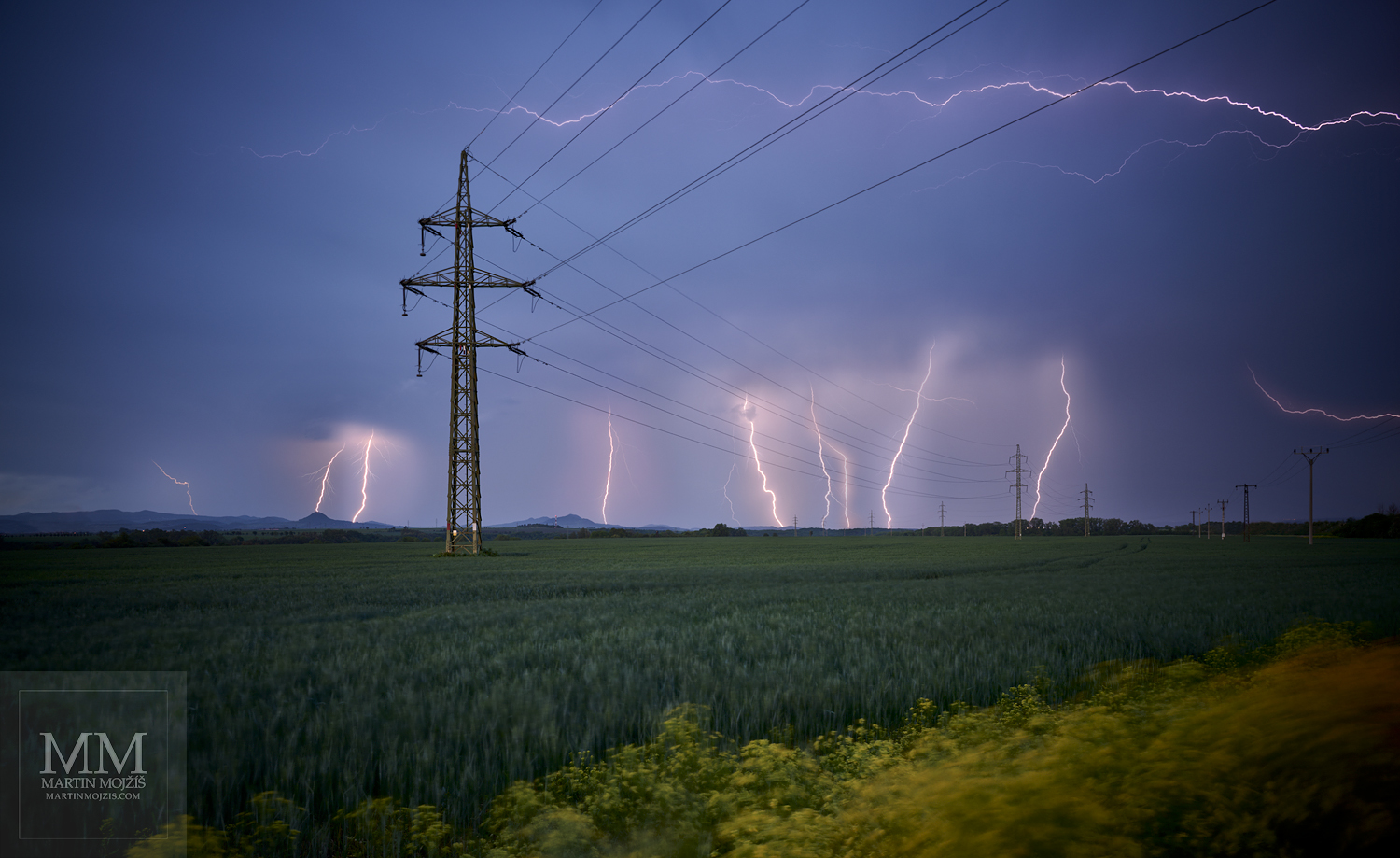 Krajina při bouři, elektrické vedení, mnoho blesků. Umělecká velkoformátová fotografie Energie pozdního jara. Fotograf Martin Mojžíš.