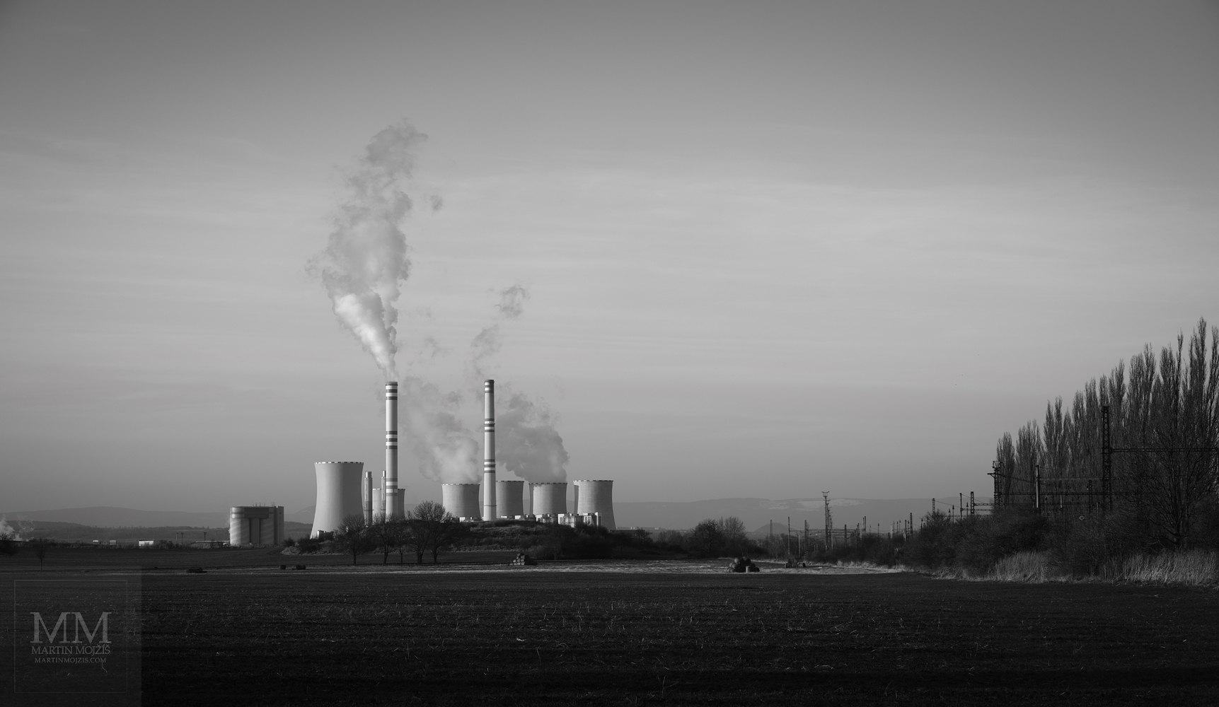 Tepelná elektrárna v krajině. Velkoformátová černobílá umělecká fotografie krajiny s názvem KRAJINA S ELEKTRÁRNOU. Fotograf Martin Mojžíš.