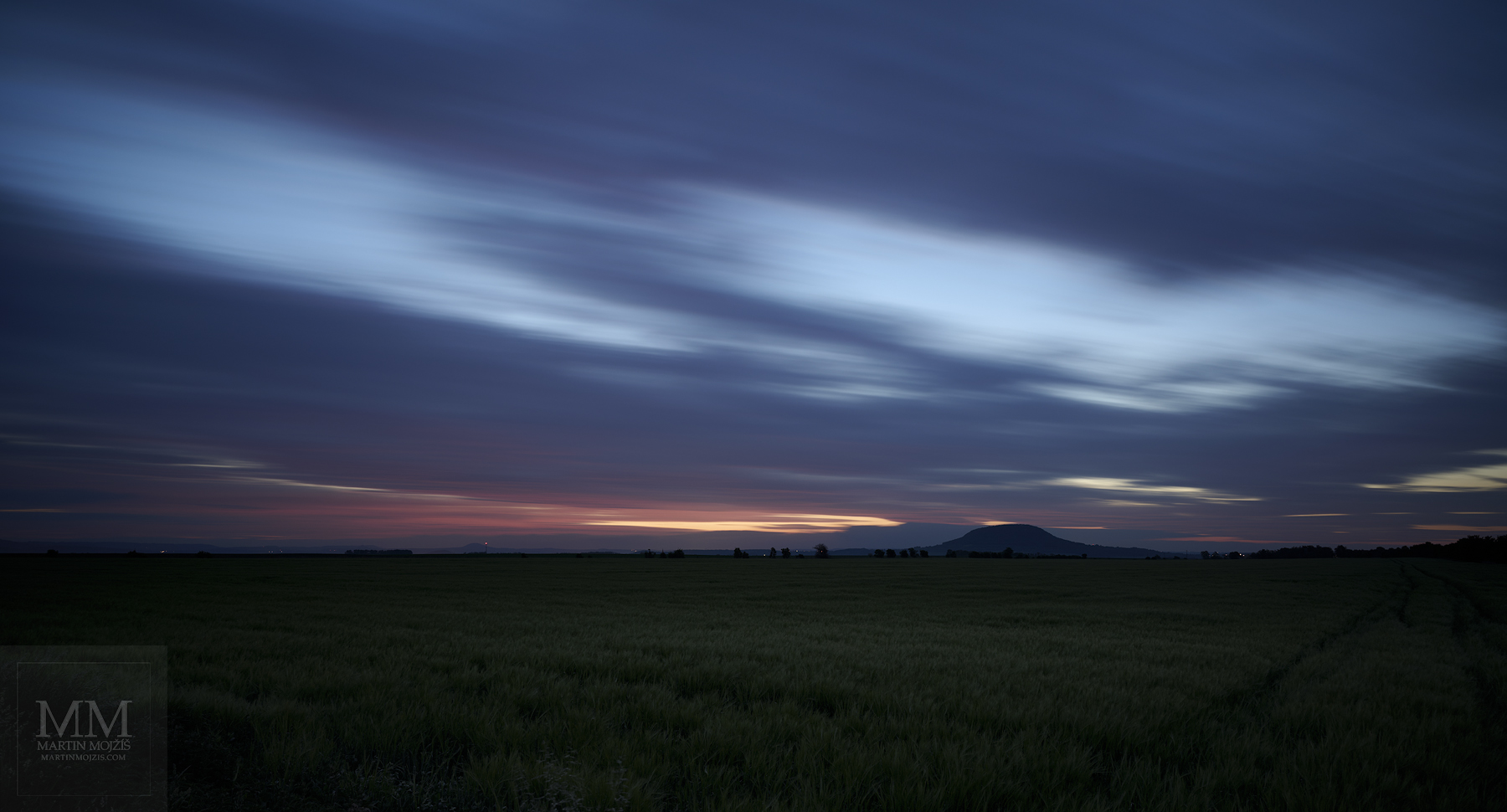 Ranní barevné letící mraky nad krajinou ve svítání. Velkoformátová umělecká fotografie krajiny s názvem ČTVRTÁ HODINA RANNÍ. Fotograf Martin Mojžíš.
