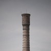 A tall brick factory chimney.