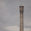 A tall brick factory chimney above the factory roofs.