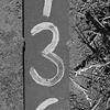 Plechová tabulka s čislem 136 ležící na prašné cestě u pole.