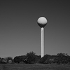 The white watertower in the landscape.