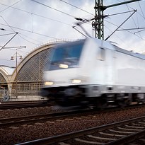 Pohybově rozostřená elektrická lokomotiva Bombardier Traxx. Profesionální fotografování dopravních prostředků, především železnice.